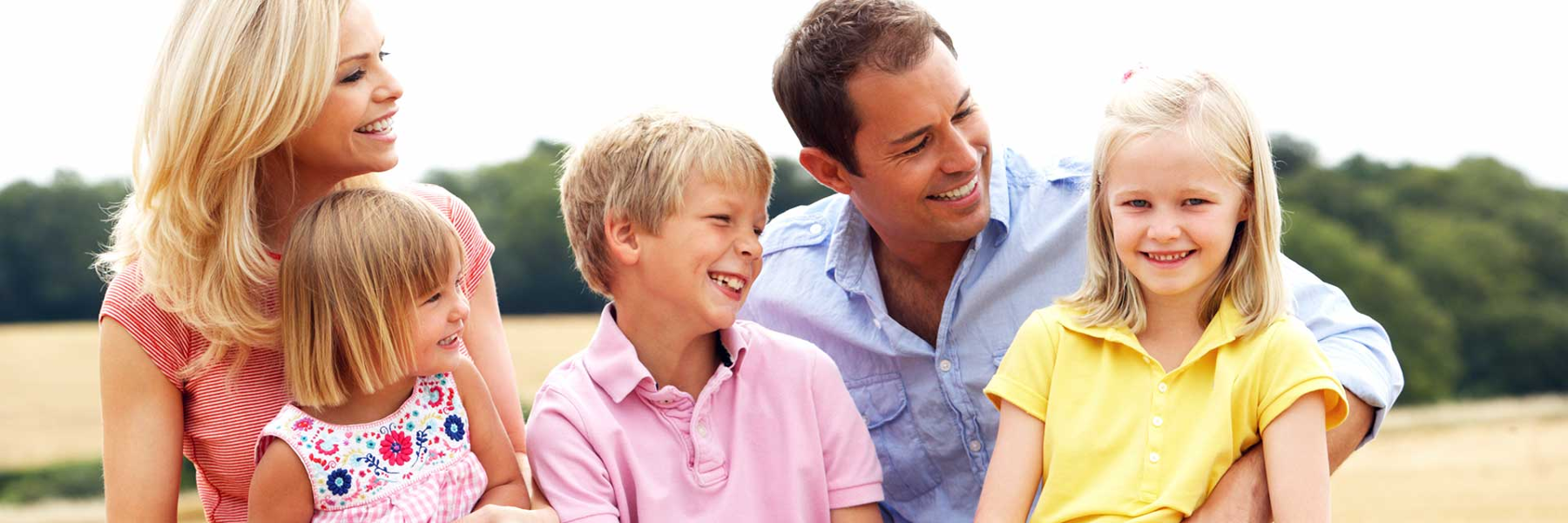 A family of three smiling after a dentist appointment